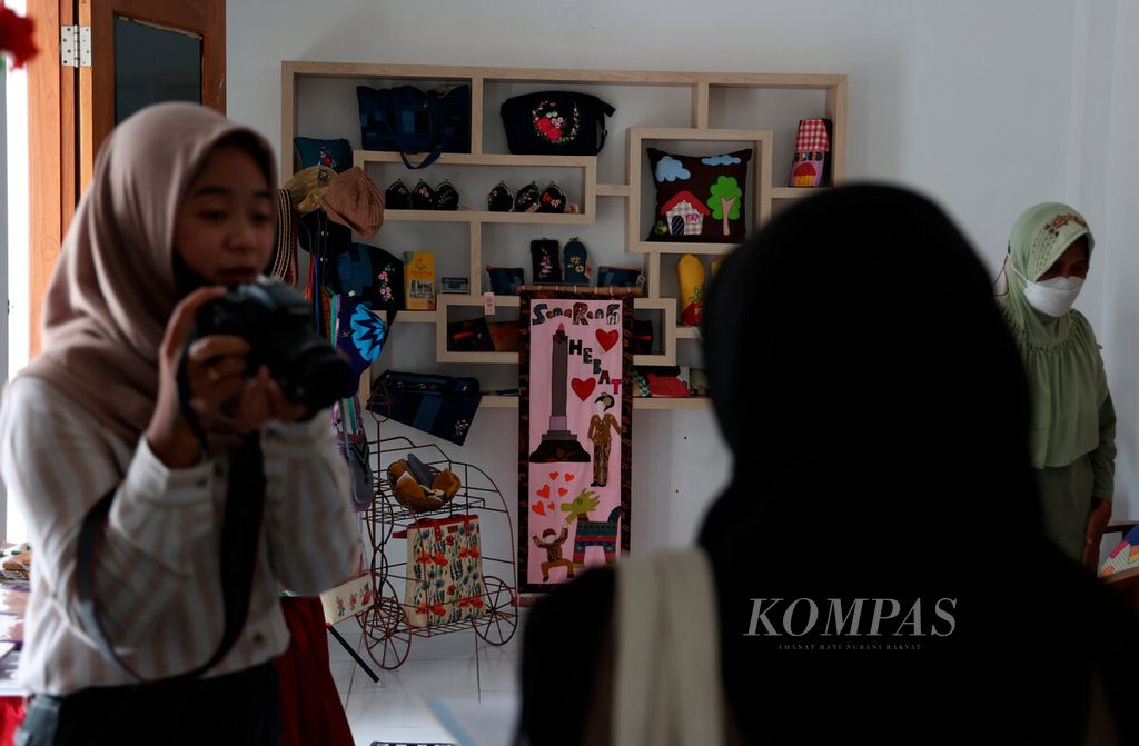 A group of teenagers created digital content to introduce products from training outcomes for residents at the RW Srondol Wetan Hall in Semarang City, Central Java, on Tuesday (22/11/2022). Various skill training programs are routinely held for housewives and women in the area to provide ideas and opportunities for small business ventures.