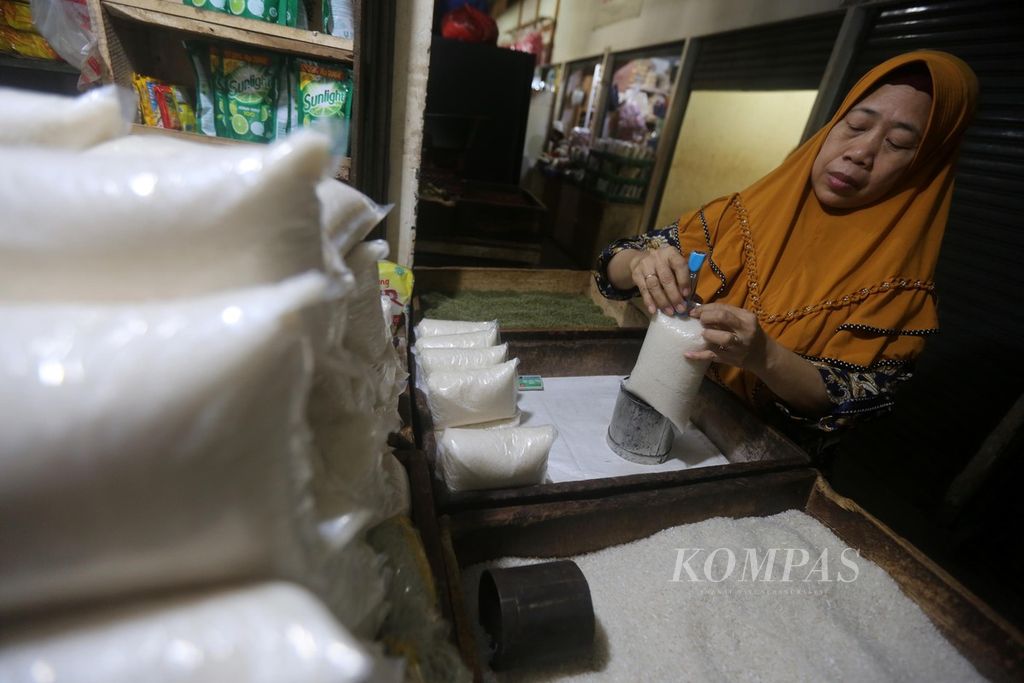 Pedagang membungkus gula pasir untuk dijual kembali di Pasar Senen, Jakarta Pusat, Senin (23/11/2020).