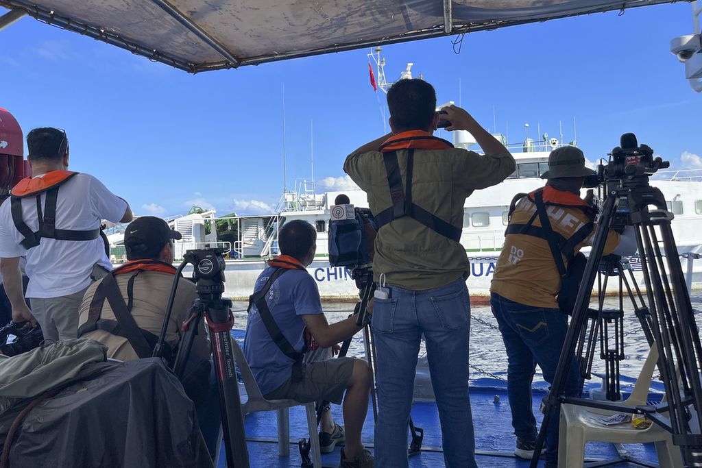 Sejumlah wartawan di atas kapal Penjaga Pantai Filipina, BRP Cabra, menyaksikan kapal penjaga pantai China mengejar mereka saat mendekati Beting Second Thomas, atau Beting Ayungin, di perairan Laut China Selatan, 10 November 2023. 