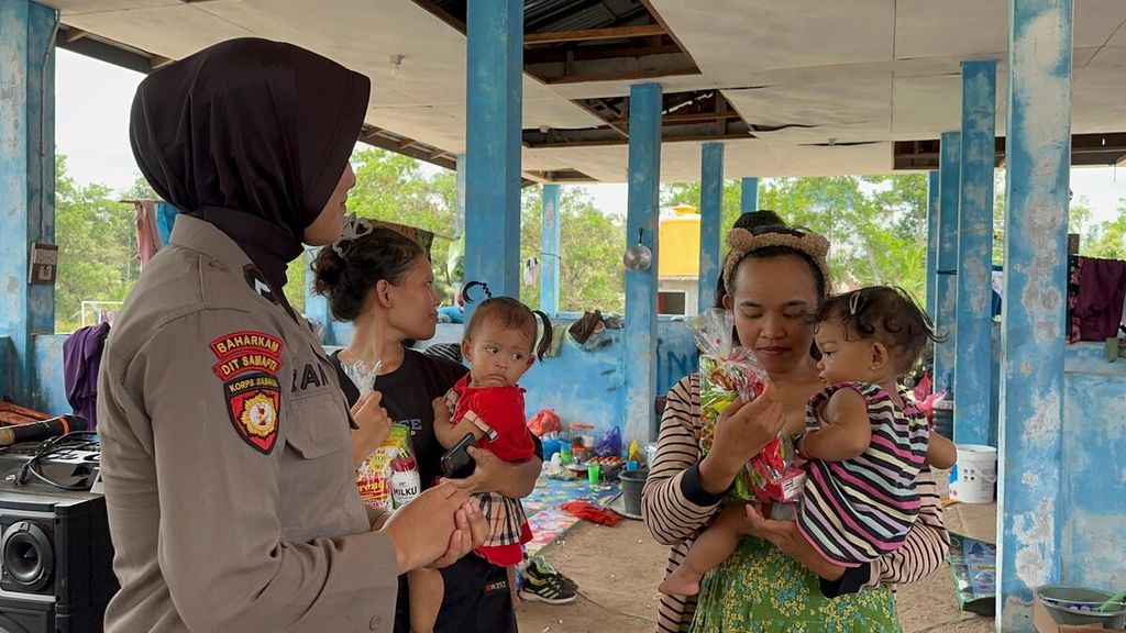 Petugas dari Polda Kalteng menghibur pengungsi dan memberikan sejumlah bantuan untuk mereka di Seruyan Raya, Kalteng, Senin (25/9/2023).