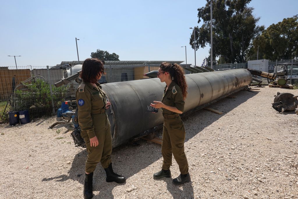 Anggota militer Israel berdiri di samping rudal balistik Iran yang jatuh di Israel, di dekat kota Kiryat Malachi, Israel, pada 16 April 2024. 