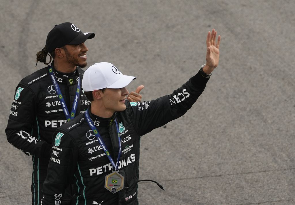 Duo Mercedes, Lewis Hamilton (atas) dan George Russell, melambaikan tangannya ke penggemar seusai kualifikasi balapan Formula 1 seri Brasil di Sirkuit Interlagos, Sao Paulo, Brasil, Sabtu (12/11/2022) waktu setempat.