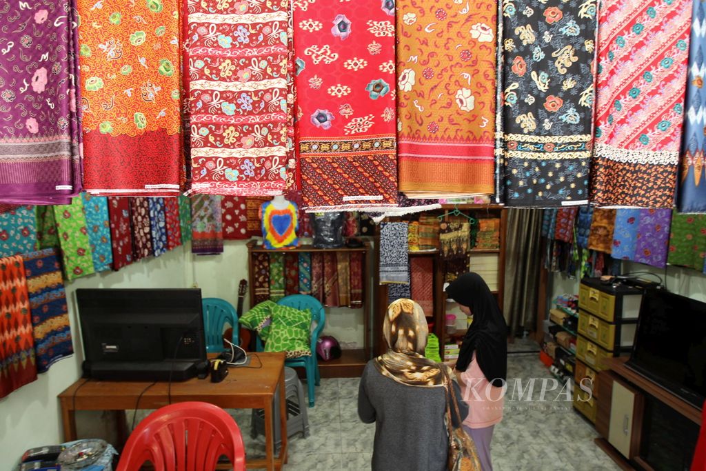 Yanti floriza (kanan) melayani calon pembeli melihat batik-batik khas Bengkulu di Toko Joewada, Kota Bengkulu, Bengkulu, Minggu (5/6/2016).