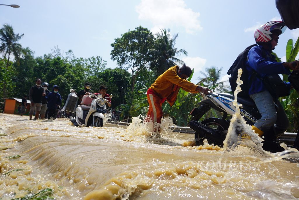 Banjir menggenangi akses jalan dari Jeruklegi ke Kawunganten di Kabupaten Cilacap, Jawa Tengah, 21 Juli 2021.