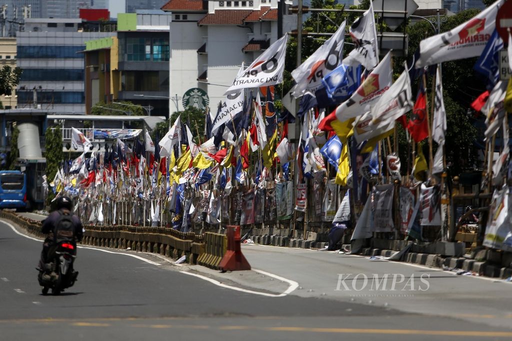 Kondisi ruas Jalan Mampang Raya, Jakarta, yang dipenuhi alat peraga kampanye, Senin (16/1/2024). 