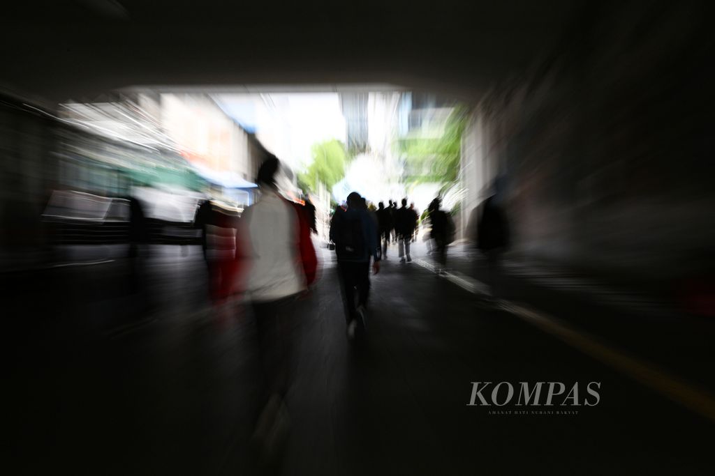 Silhouettes of workers rushing to their workplaces or changing modes of transportation from Sudirman station, Central Jakarta, Friday (11/19/2021). Many of the workers in the capital are the sandwich generation who have to share their income with their families and support their parents' economy.