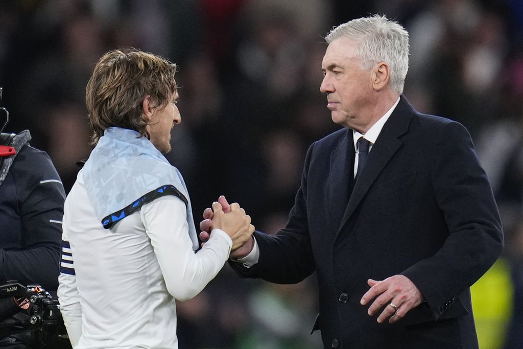 Real Madrid coach Carlo Ancelotti (right) congratulates Luka Modric after the match against Sevilla in the Spanish League match at Santiago Bernabeu Stadium, Madrid, Monday (26/2/2024) morning WIB.  Real won 1-0 in that game.