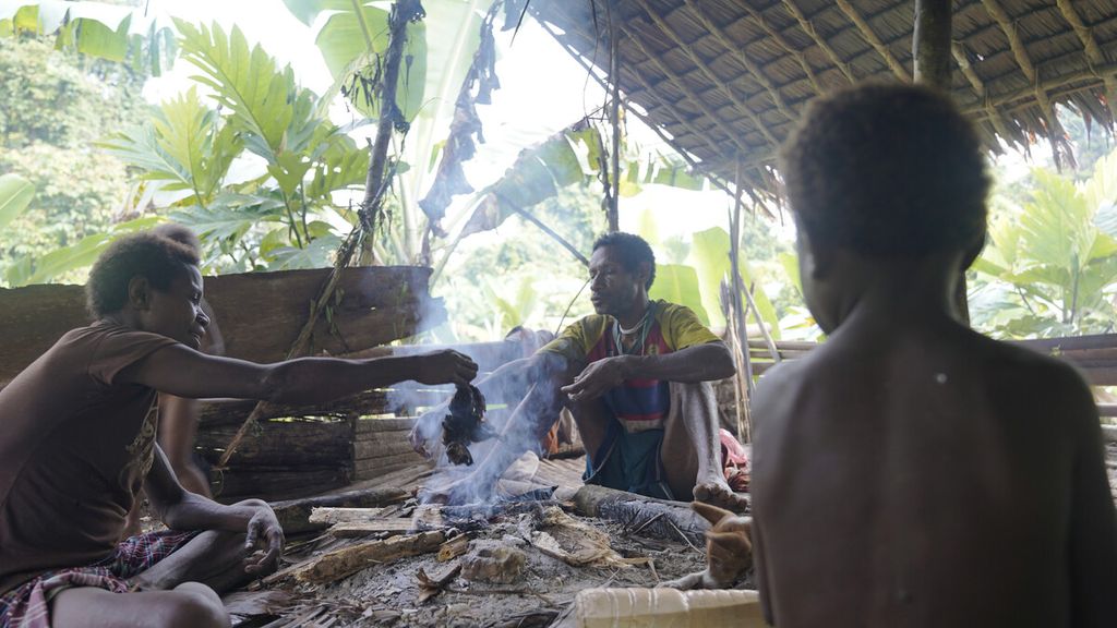  Ndahi Dayo, tetua suku Korowai, memasak bersama keluarganya di Dusun Dayo, Distrik Yanimura, Kabupaten Boven Digoel, Papua, Kamis (5/3/2020). Menurut Ndahi Dayo, tetua suku Korowai, rumah pohon dibangun tinggi untuk menghindari gigitan nyamuk dan gangguan roh jahat (<i>laloe</i>). 
