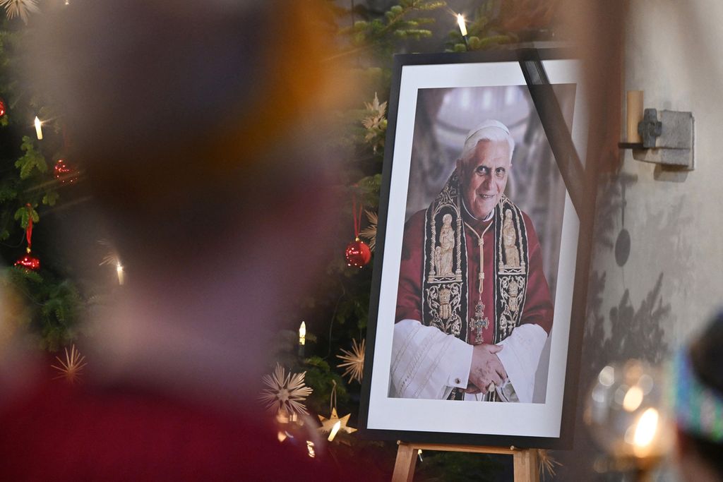 Foto Paus Emeritus Benediktus XVI diletakkan di dekat altar Gereja St Oswald di tempat kelahirannya di Marktl, Jerman pada Minggu (31/12/2022).