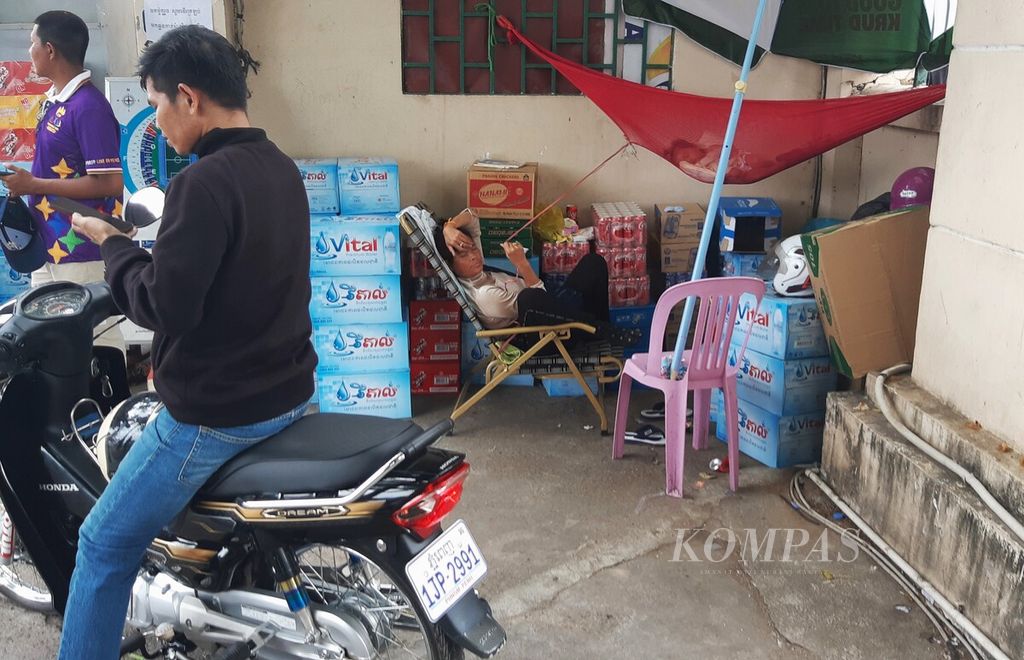 Pedagang minuman menunggu pembeli datang sambil menemani anaknya tidur siang di National Olympic Stadium Phnom Penh, Kamboja, Kamis (4/5/2023). SEA Games menjadi magnet bagi pedagang datang ke stadion utama untuk menjajakan dagangannya.