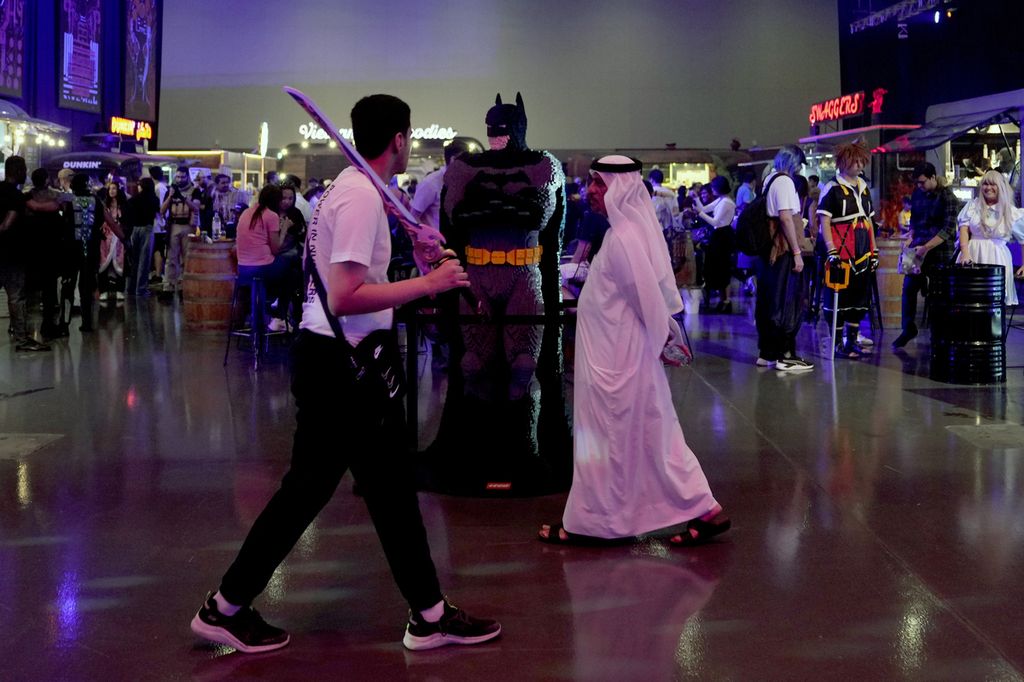 Seorang warga Uni Emirat Arab berjalan melewati sosok berpakaian ala Batman pada Festival Gim dan E-Sport Dubai di Dubai, Uni Emirat Arab, 24 Juni 2023. 