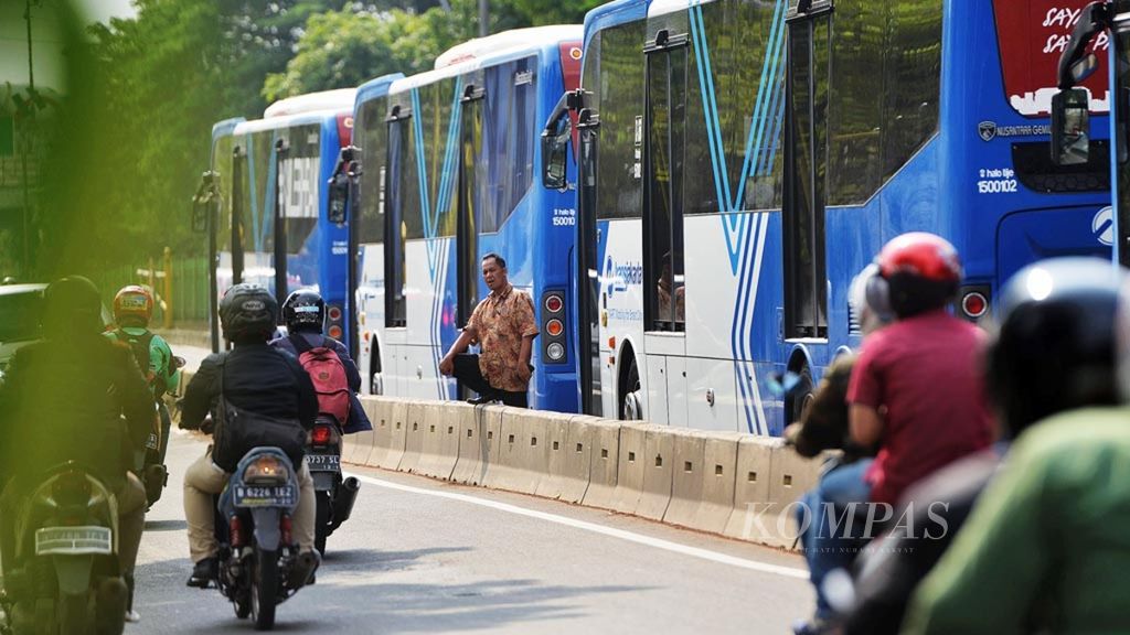 Pengemudi Transjakarta keluar dari bus untuk istirahat di Jalan Galunggung, Jakarta, Senin (2/10/2017).