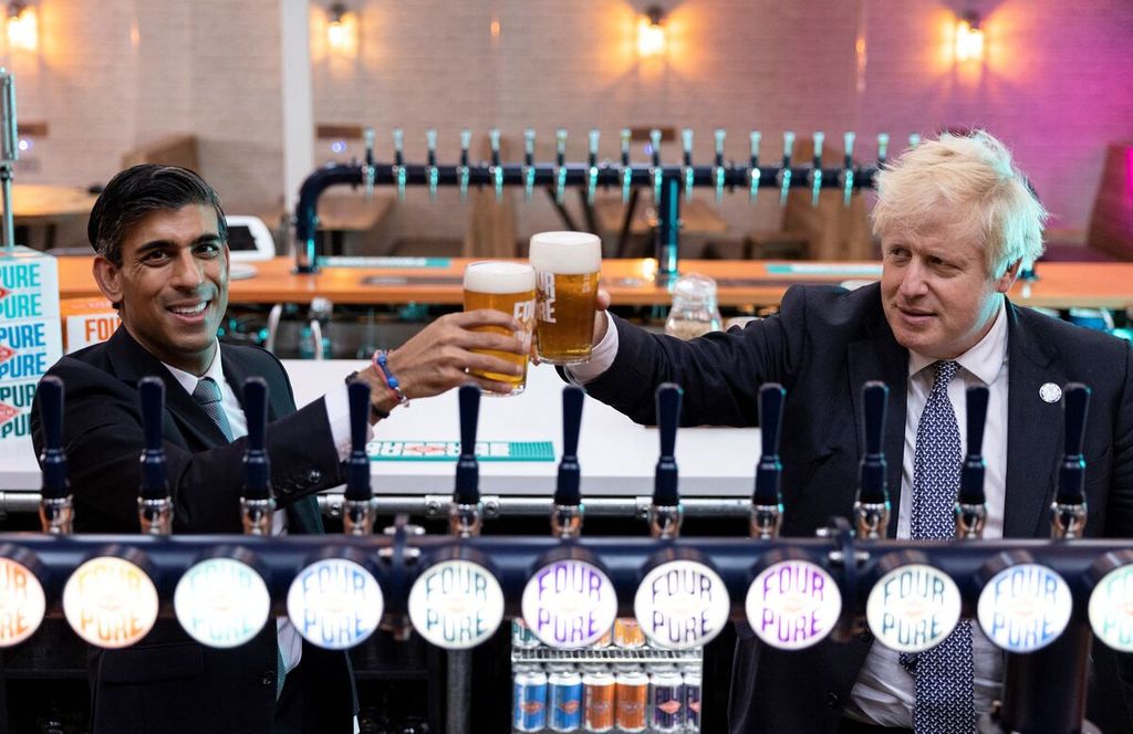 Dalam foto yang diambil pada 27 Oktober 2021 ini menunjukkan Perdana Menteri Inggris Boris Johnson (kanan) dan Menteri Keuangan Inggris Rishi Sunak saat mengunjungi Fourpure Brewery di Bermondsey, London selatan. Kedua pejabat itu didenda karena telah melanggar protokol kesehatan dalam acara ulang tahun Johnson pada tahun lalu. 
