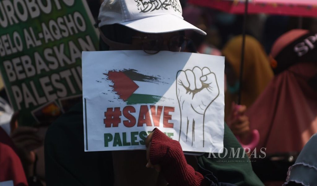 Warga yang tergabung dalam Aliansi Umat Islam Bela Palestina membawa bendera Palestina saat unjuk rasa menolak invasi Israel di Jalan Gubernur Suryo, Surabaya, Jawa Timur, Jumat (27/10/2023). 