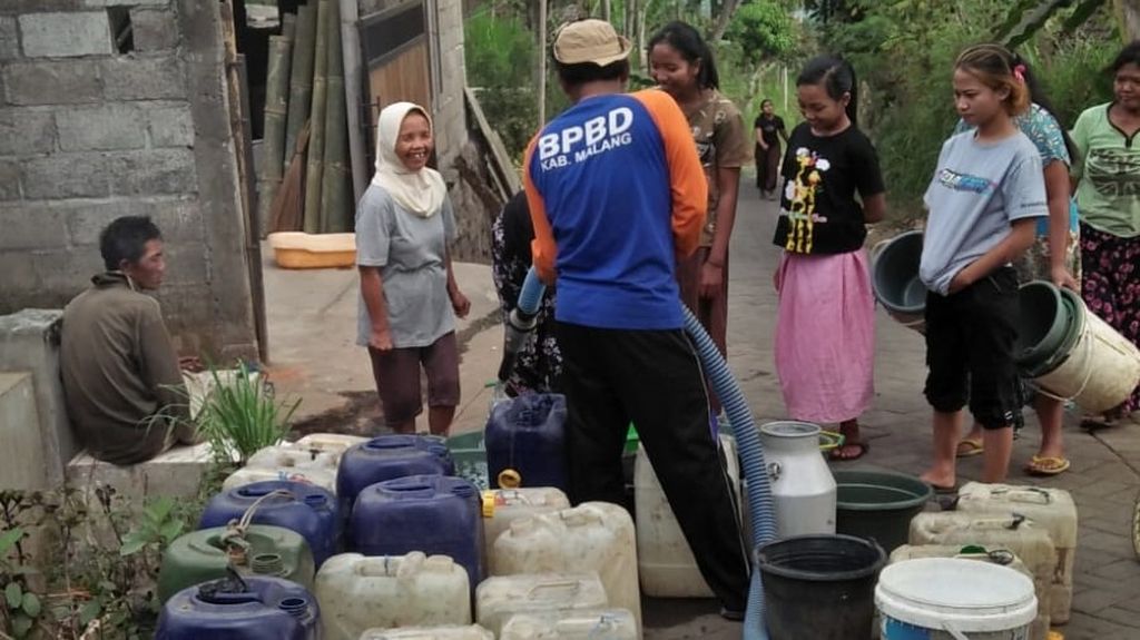 Petugas Badan Penanggulangan Bencana Daerah Kabupaten Malang, Jawa Timur, menyalurkan air bersih kepada warga di Desa Klampok, Kecamatan Singosari, Minggu (10/9/2023).