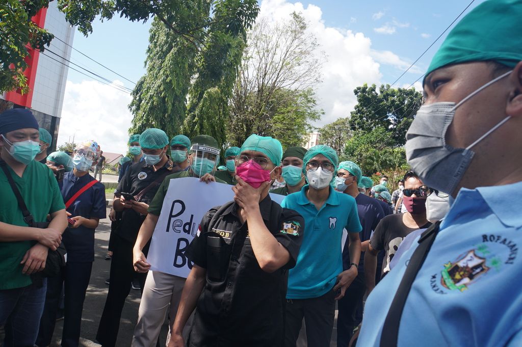 Sekitar 50 dokter residen peserta program pendidikan dokter spesialis (PPDS) Universitas Sam Ratulangi, Manado, Sulawesi Utara, menggelar aksi untuk menuntut penurunan biaya operasional pendidikan, Jumat (24/7/2020). Uang kuliah yang mencapai Rp 24 juta per semester dinilai terlalu memberatkan ketika pemasukan mereka kurang semasa pandemi Covid-19.