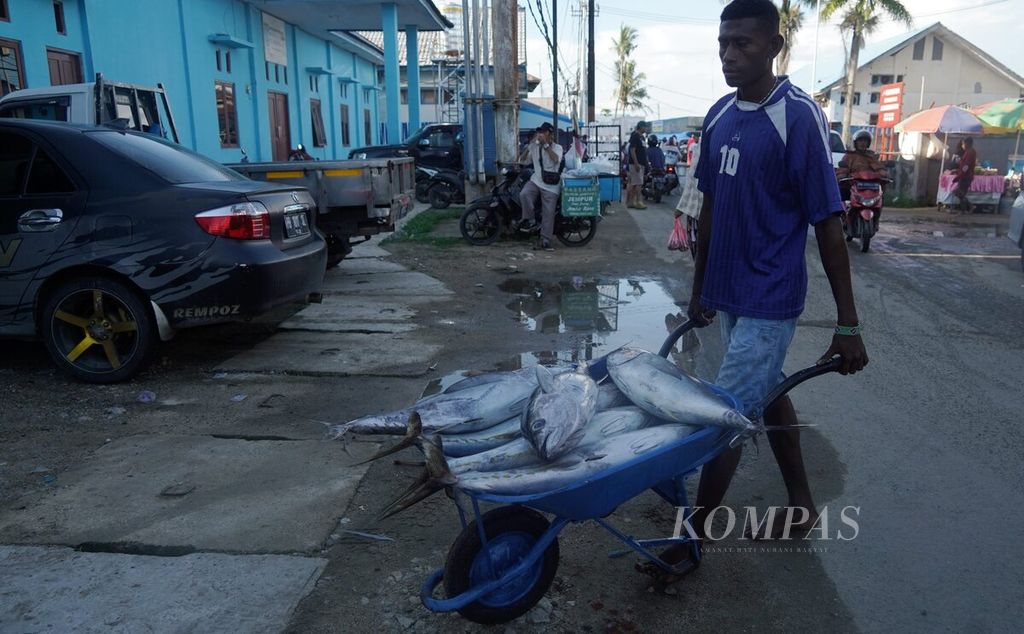 Pekerja membawa tuna ke pabrik pengolahan di Pasar Ikan Jembatan Puri, Kota Sorong, Papua Barat Daya, Minggu (10/6/2023).
