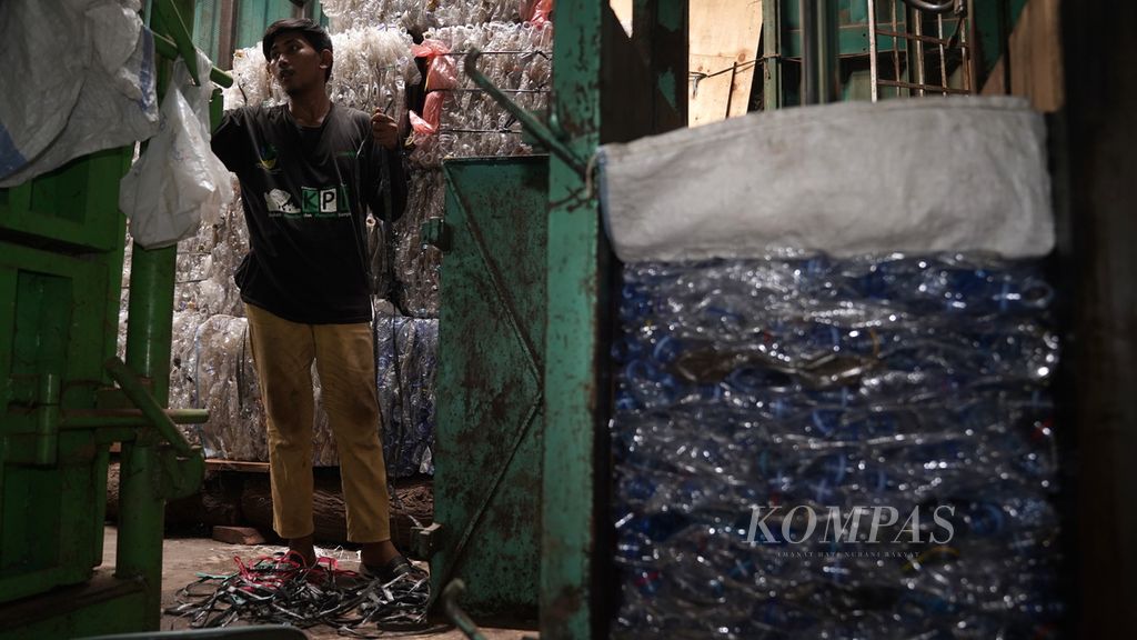 Yudi (28) bersiap mengikat botol minuman kemasan berbahan plastik yang sudah dipres di Yayasan Kumala di Tanjung Priok, Jakarta Utara, Selasa (30/5/2023). 