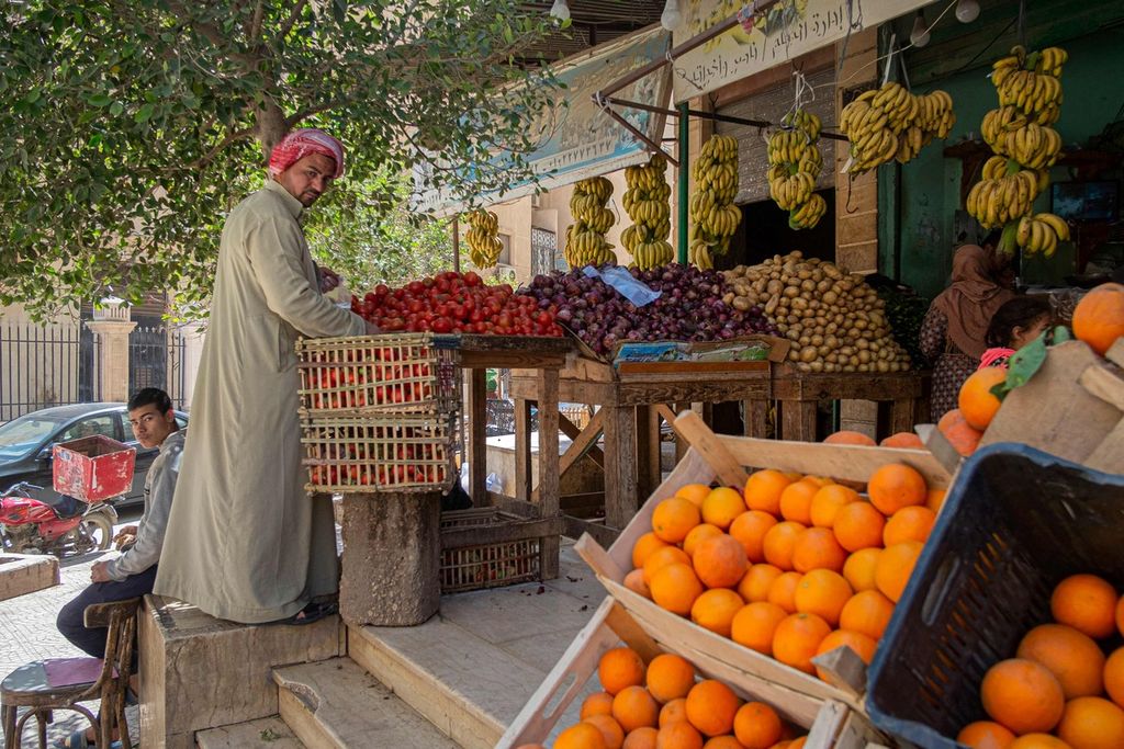 Seorang pedagang buah-buahan tengah mengatur dagangannya di sebuah toko buah di Kairo, Mesir, Kamis (17/3/2022).