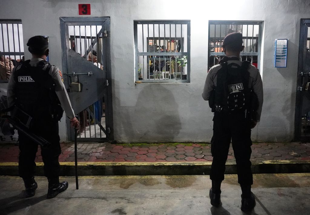 Polisi mengamankan proses penggeledahan di Lapas Kelas II B Slawi, Kabupaten Tegal, Jawa Tengah, Rabu (17/2/2021) malam. Petugas gabungan dari Lapas Kelas II B Slawi, Kepolisian Resor Tegal, dan Badan Narkotika Nasional Kota Tegal menggeledah sel tahanan yang dihuni 350 napi tersebut setelah terungkapnya kasus peredaran narkoba jaringan internasional yang dikendalikan oleh seorang narapidana dari Lapas Kelas II B Slawi. Dalam kejadian tersebut, petugas menemukan enam ponsel, sejumlah pengisi daya ponsel, <i>headset</i> ,dan sejumlah senjata tajam.