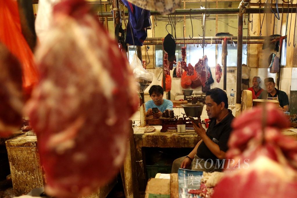 Pedagang daging sapi memainkan gadgetnya saat menunggu calon pembeli di Pasar Kebayoran Lama, Jakarta Selatan, Minggu (4/9/2022). 