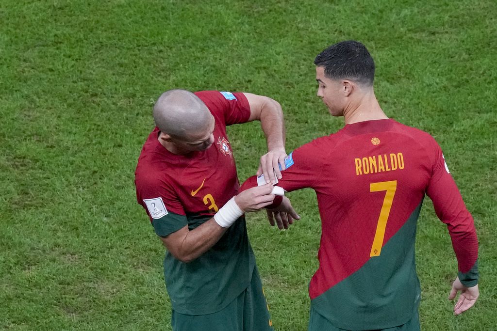 Pemain Portugal Pepe memasang tanda kapten di lengan Cristiano Ronaldo dalam laga 16 besar Piala Dunia Qatar 2022 melawan Swiss di Stadion Lusail, Rabu (7/12/2022) dini hari WIB. Portugal menang telak 6-1 tetapi Ronaldo kembali gagal melesakan gol di laga itu. 