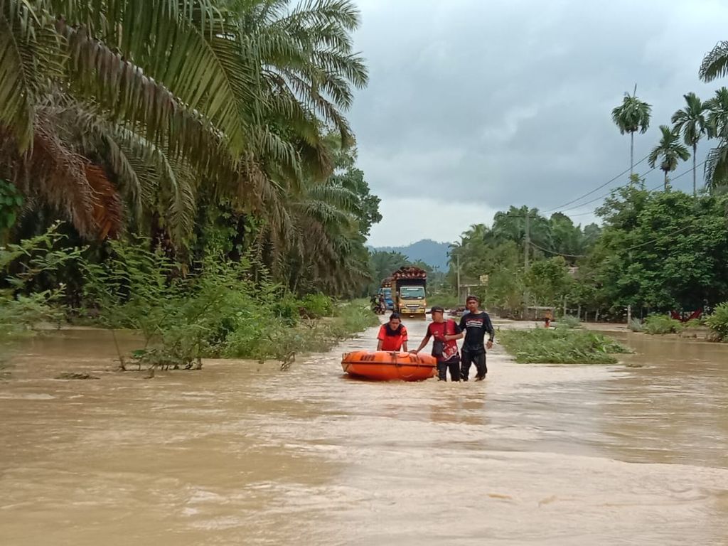 Petugas BPBD Dharmasraya membawa perahu karet untuk mengevakuasi warga terdampak banjir di Kecamatan Timpeh, Dharmasraya, Sumatera Barat, Jumat (10/3/2023). Hujan deras sejak malam hingga pagi memicu Batang (Sungai) Timpeh dan sungai kecil lainnya meluap ke permukiman.