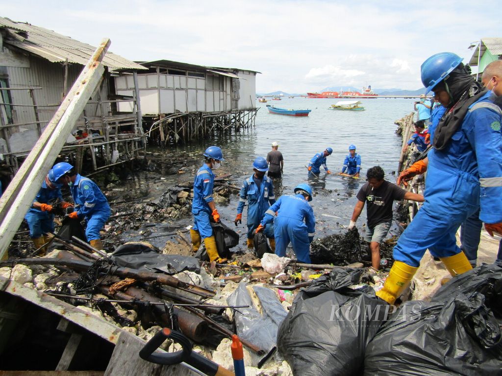 Petugas membersihkan sampah plastik dan limbah oli yang mencemari kawasan pesisir Kecamatan Panjang, Kota Bandar Lampung, Lampung, pada Kamis (10/3/2022).