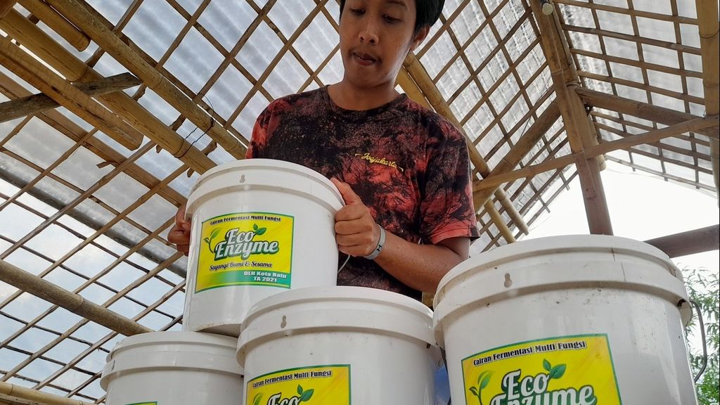 Haris Yudistiro (24) menata bak plastik yang digunakan dalam proses pembuatan <i>eco-enzyme</i> di Dusun Gondang, Desa Tulungrejo, Kecamatan Bumiaji, Kota Batu, Jawa Timur, Senin (13/6/2022).