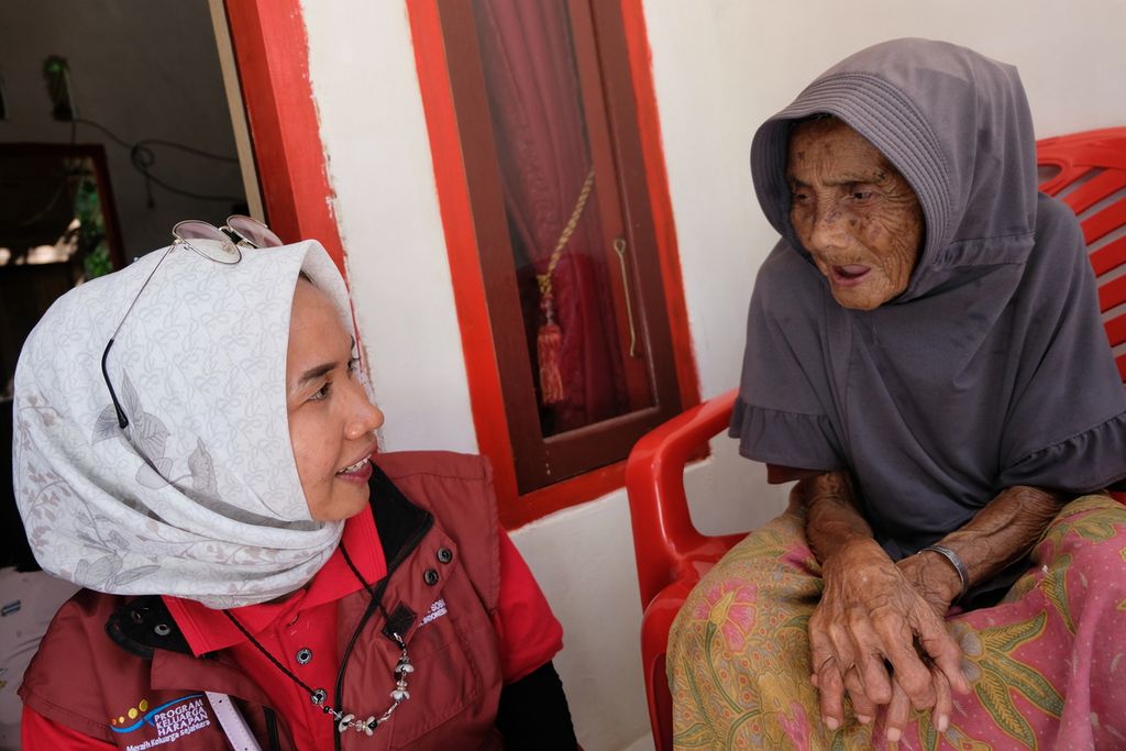 Seorang lansia di Kabupaten Dharmasraya, Sumatera Barat, Halimah (75, kanan), berbincang dengan pendamping dari Kementerian Sosial, Senin (29/5/2023). Halimah merupakan salah satu warga lansia penerima bantuan sosial berupa rumah sejahtera terpadu (RST). RST diberikan, antara lain, ke warga lansia tunggal yang hidup dalam kemiskinan.
