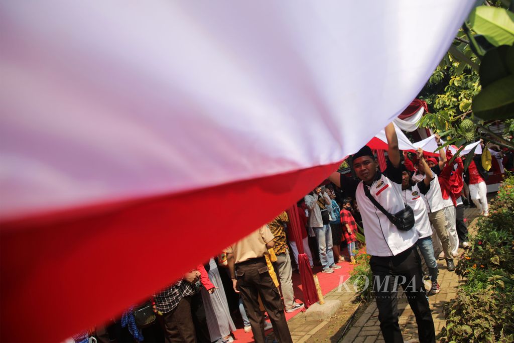 Warga ikut membentangkan bendera Merah Putih sepanjang 3.522 meter mengelilingi Setu Parigi, Tangerang Selatan, Banten, dalam acara Pondok Aren Berkibar, Kamis (18/8/2022). Kegiatan ini digelar untuk memeriahkan HUT Ke-77 Kemerdekaan Indonesia. 
