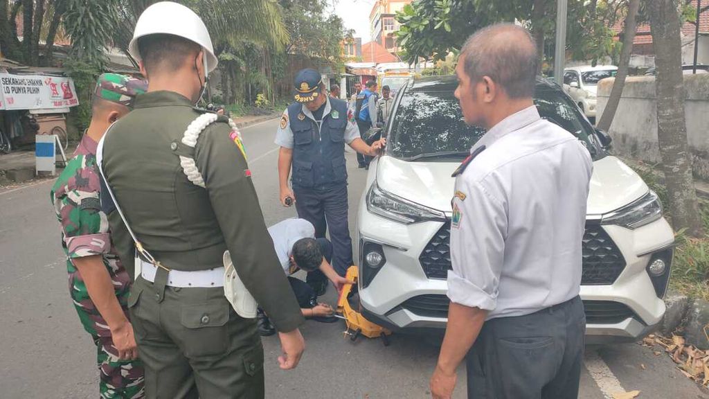 Petugas menggembok kendaraan yang diparkir di tempat yang tidak semestinya di Kota Malang, Jawa Timur. Persoalan parkir menjadi perhatian pemerintah setempat, utamanya menjelang Lebaran 2023. Sebab, parkir sembarangan selama ini menjadi salah satu penyebab kemacetan di Kota Malang.