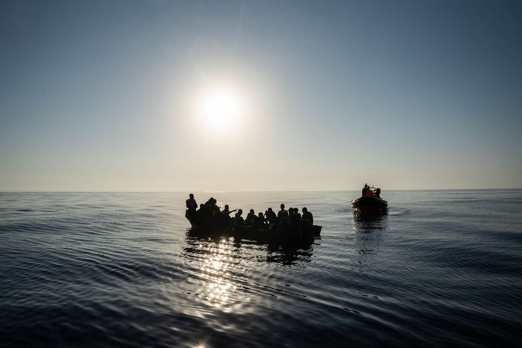 Dalam foto yang diambil pada 3 Agustus 2023 ini tampak sebagian dari 266 imigran yang berupaya melintasi Laut Tengah, menyesaki perahu-perahu karet saat dievakuasi oleh sebuah lembaga amal asal Spanyol, Proactiva Open Arms di lepas pantai Libya. 