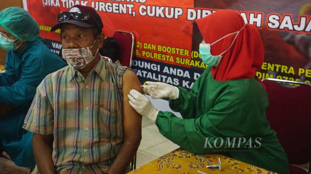 Peserta vaksinasi penguat yang digelar Polres Kota Surakarta disuntik vaksin Covid-19 di Pasar Klewer, Kota Surakarta, Jawa Tengah, Jumat (25/2/2022).