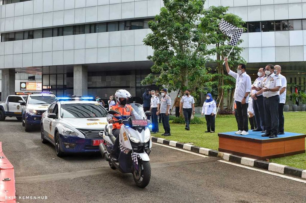 Menteri Perhubungan Budi Karya Sumadi mengangkat bendera untuk memberangkatkan para petugas yang akan memantau Posko Angkutan Lebaran Terpadu 2022 di depan  Kementerian Perhubungan, Jakarta, Senin (25/4/2022).