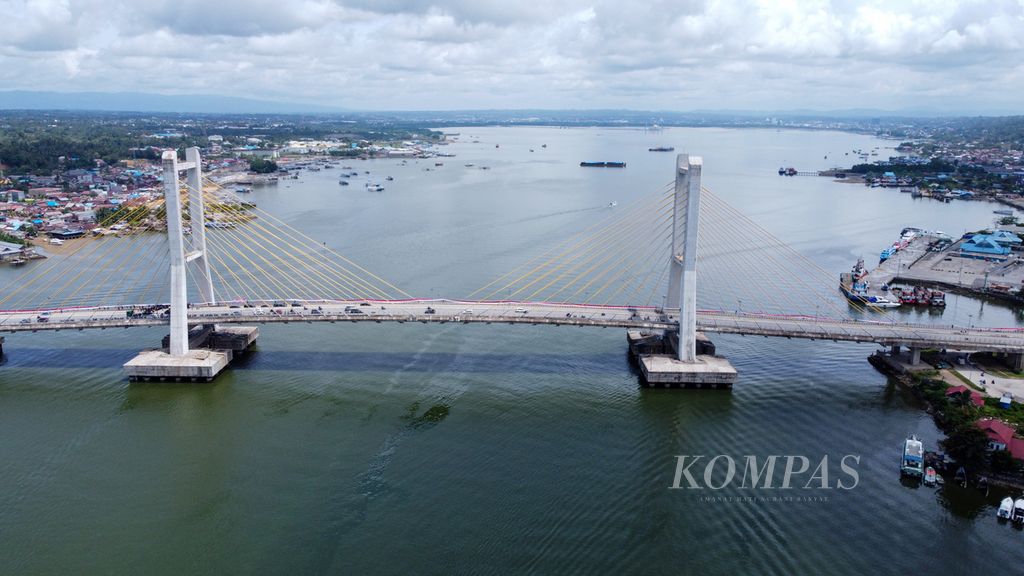 Ratusan mahasiswa, pelajar, dan pemuda membentangkan bendera sepanjang 770 meter di Jembatan Teluk Kendari, Sulawesi Tenggara, Rabu (17/8/2022). 
