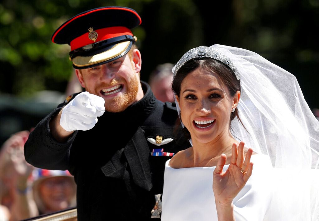 Pangeran Harry dan Meghan Markle menaiki kereta kencana setelah peresmian pernikahan mereka di London, Inggris, pada 19 Mei 2018. 