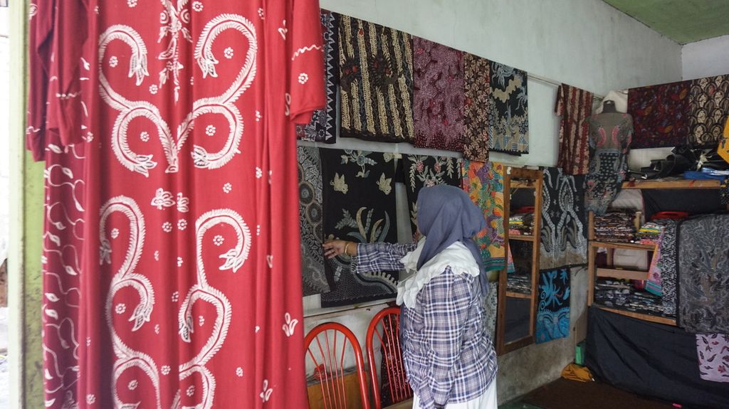 Konsumen batik dari Yogyakarta sedang memilih batik tulis warna alam di rumah produksi Mahkota, Bangkalan, Pulau Madura, Jawa Timur, Sabtu (23/7/2022). Batik tulis warna alam menjadi salah satu produk budaya warga Pulau Madura yang kian dikenal dan digemari. 