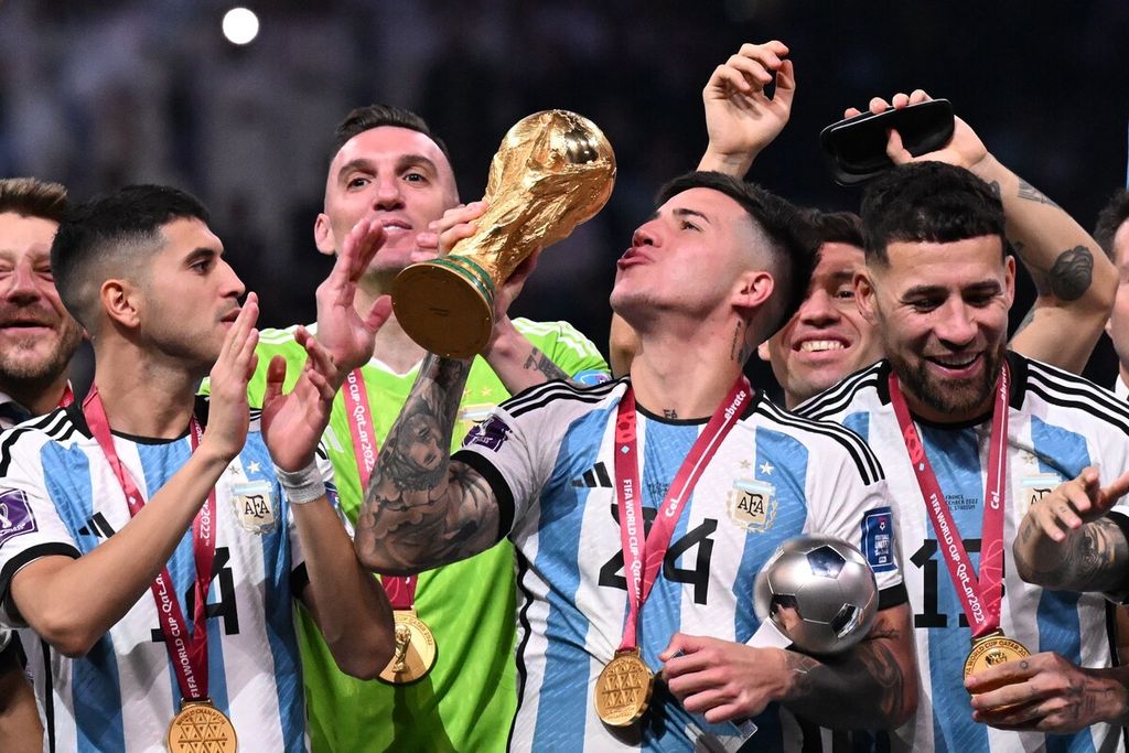 Gelandang Argentina Enzo Fernandez mengangkat trofi Piala Dunia dan pemain terbaik Piala Dunia 2022 di Stadion Lusail pada 18 December 18, 2022. 