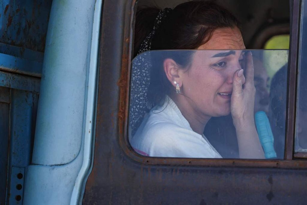 Seorang perempuan menangis di sebuah truk di pusat Palang Merah Armenia setelah melintasi perbatasan dekat Kornidzor, Armenia, Rabu (27/9/2023).
