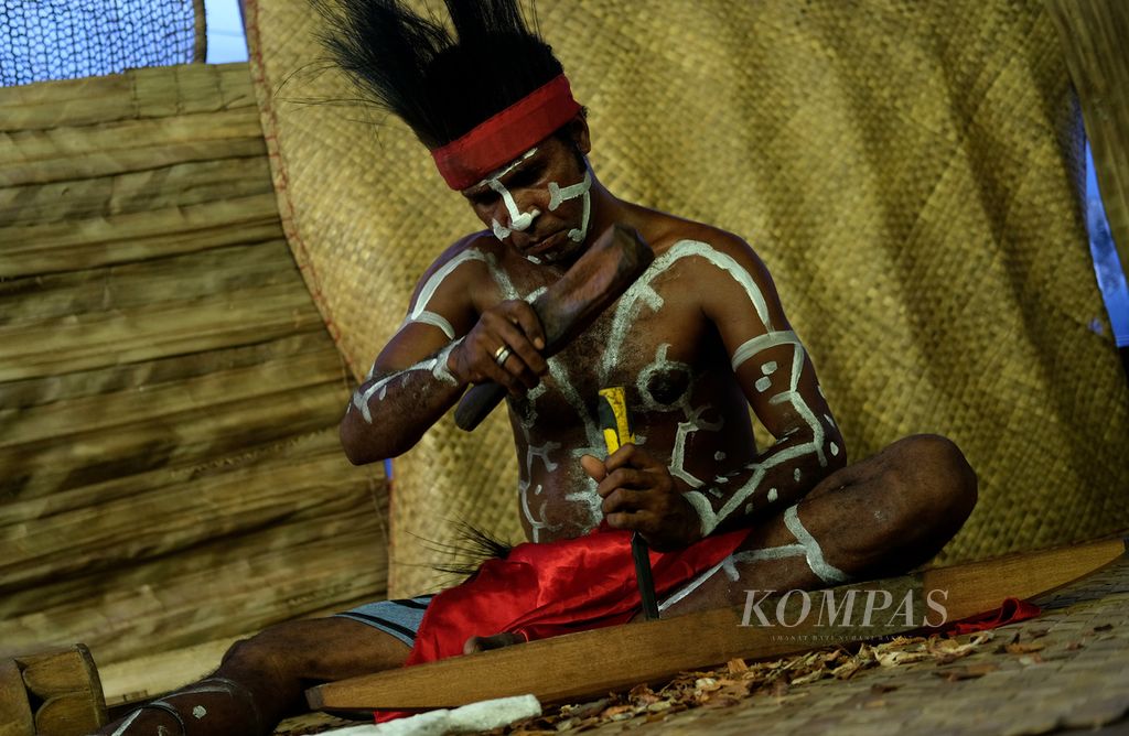 Pengukir suku Kamoro mempraktikkan pembuatan ukiran kapal di bengkel kerja dan galeri ukiran Yayasan Maramowe di Kampung Nawaripi, Distrik Wania, Kabupaten Mimika, Papua, Jumat (18/3/2022).