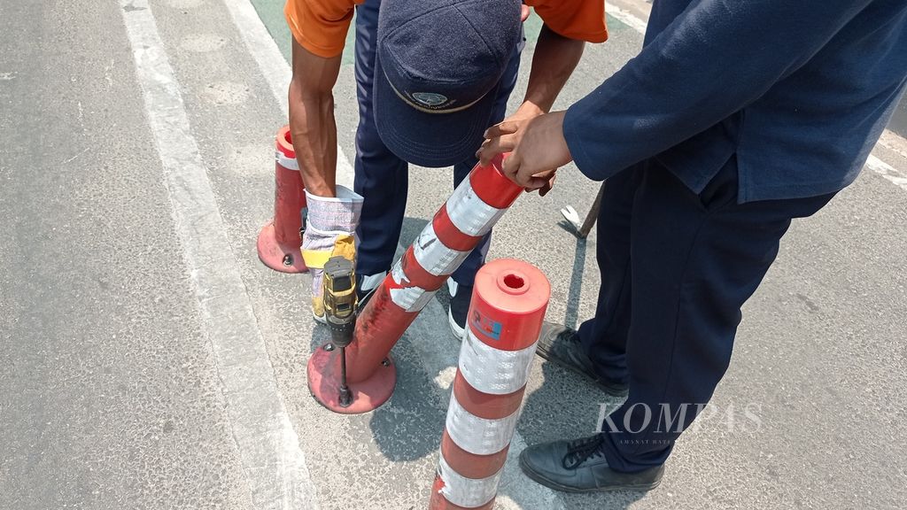 Petugas dari Cepat Respons Masyarakat Dinas Perhubungan DKI Jakarta mencopot <i>stick cone</i> lajur sepeda yang rusak di samping Menara BNI, Jakarta Pusat, Rabu (18/10/2023).