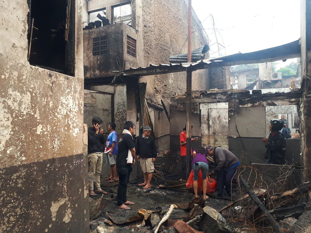 Warga melihat kondisi rumah yang terbakar di Pela Mampang, Mampang Prapatan, Jakarta Selatan, Selasa (27/12/2022).