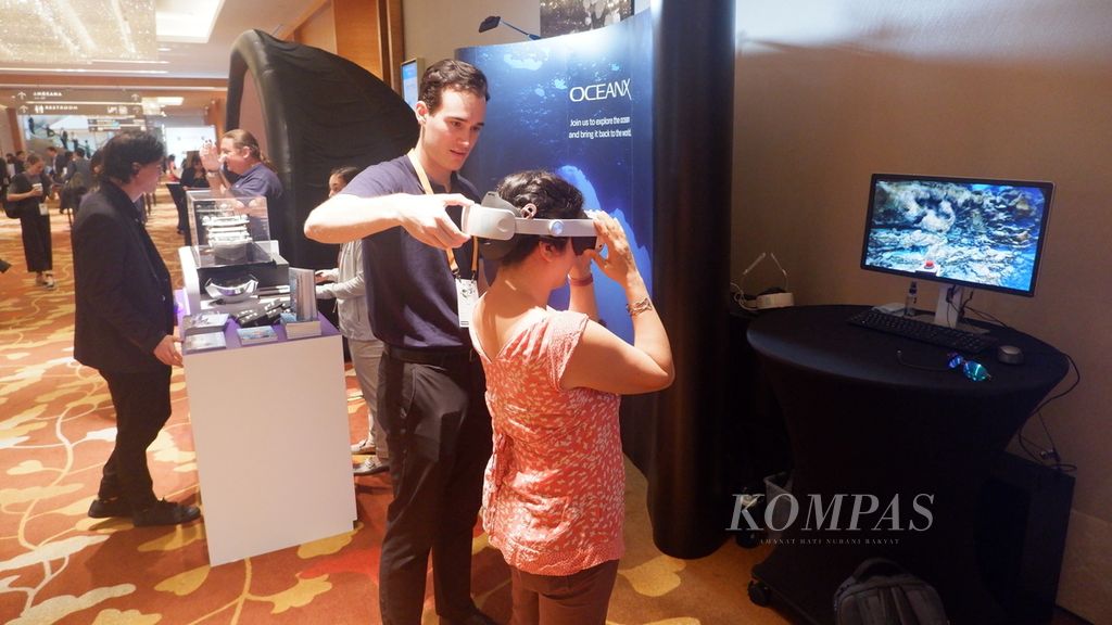 Pengunjung mencoba sensasi mengeksplorasi lautan di <i>booth</i> OceanX dalam Konferensi Filantropi Asia 2024 di Expo Sands &amp; Convention Centre, Marina Bay Sands, Singapura, Selasa (16/4/2024).
