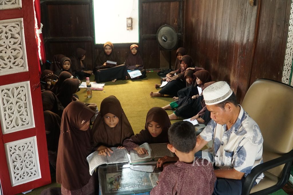 Anak-anak belajar mengaji dengan seorang guru di Rumah Gadang Kajang Padati di Kelurahan Gunung Sarik, Kecamatan Kuranji, Kota Padang, Sumatera Barat, Selasa (18/10/2022).