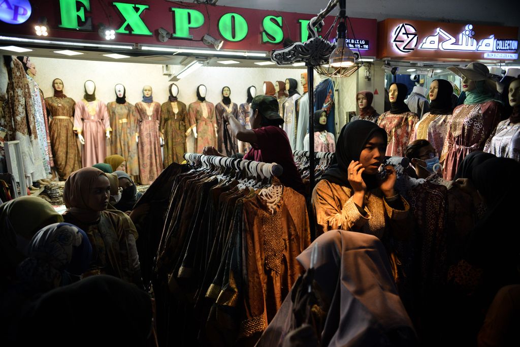Pedagang menawarkan dagangannya ke pengunjung Pasar Tanah Abang, Jakarta Pusat, Minggu (9/4/2023). Dua pekan menjelang Lebaran 2023, warga mulai memadati Pasar Tanah Abang untuk membeli baju baru. 