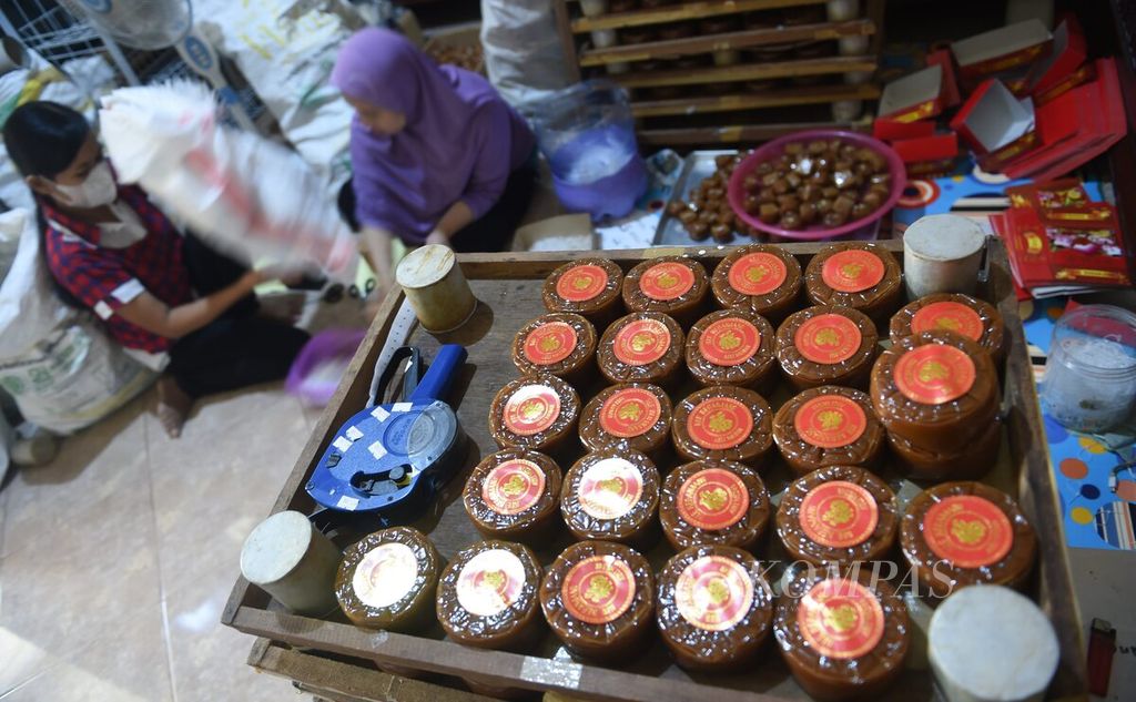 Aktivitas pengepakan kue keranjang di Jalan Kalidami, Surabaya, Jawa Timur, Kamis (12/1/2023). Menurut pemilik usaha Feri Andrea, permintaan kue keranjang terus meningkat jelang Imlek. Dalam satu hari industri rumahan kue keranjang dapat menghasilkan 600 kue keranjang ukuran besar. Kue keranjang dibuat dalam tiga ukuran, yaitu besar, sedang, dan kecil. Harga kue keranjang Rp 28.000-Rp 30.000 per kemasan.