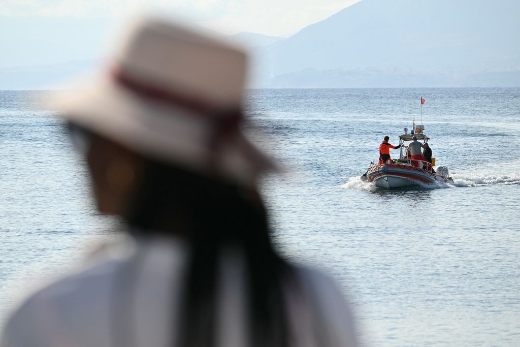 Seorang perempuan menyaksikan tim penyelamat bekerja di Porticello dekat Palermo, Italia, Rabu (21/8/2024), dua hari setelah kapal pesiar mewah berbendera Inggris, Bayesian, tenggelam.