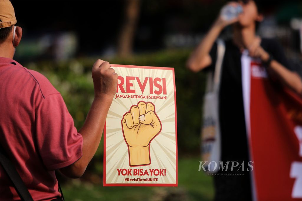Aktivis yang tergabung dalam Paguyuban Korban Kriminalisasi UU ITE (Paku ITE) membawa poster saat aksi damai menuntut Revisi Total UU ITE di Jakarta, Minggu (28/5/2023). 