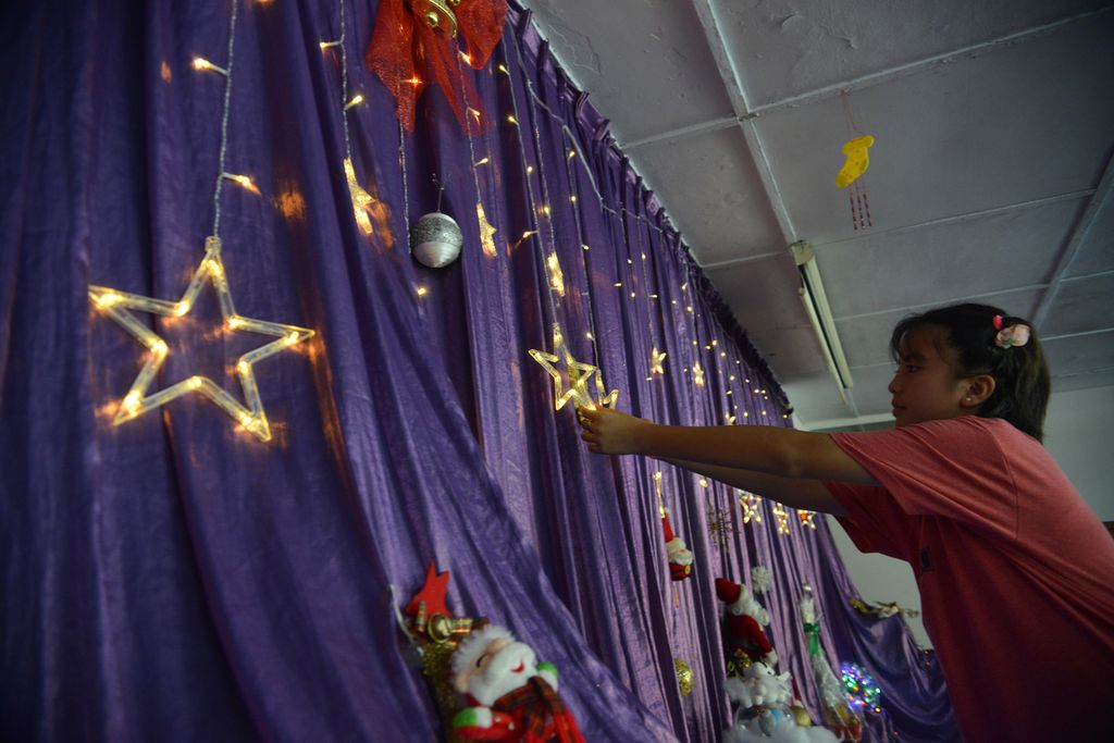 Salah seorang anak asuh Rumah Hati Suci, Tanah Abang, Jakarta Pusat, mempersiapkan hiasan natal, Senin (19/12/2022), menjelang perayaan Natal 2022. 